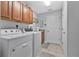 Well lit laundry room with washer, dryer, neutral colored cabinets, and tile floors at 4221 Kezar Ct, Belle Isle, FL 32812