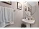 Stylish powder room features a pedestal sink, modern decor, and a decorative mirror at 4221 Kezar Ct, Belle Isle, FL 32812