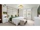 Modern bedroom with a decorative mirror wall, a decorative chandelier and bench seating at 4310 Lana Ave, Davenport, FL 33897