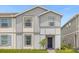 Charming two-story townhome featuring gray siding, well-manicured lawn, and inviting entryway at 4310 Lana Ave, Davenport, FL 33897