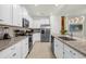 Well-equipped kitchen featuring white cabinets, granite countertops, and stainless steel appliances at 4310 Lana Ave, Davenport, FL 33897