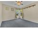 This bedroom has a ceiling fan and carpeted floor and contains a large window at 485 Whittingham Pl, Lake Mary, FL 32746