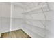 Walk-in closet features white walls and multiple shelves for storing clothes and accessories at 485 Whittingham Pl, Lake Mary, FL 32746