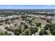 Expansive aerial view showcasing a rural community with scattered homes, lush greenery, and open fields under a sunny sky at 4895 Cr 134B, Wildwood, FL 34785