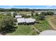 An aerial view of the house with manicured lawns, mature trees, and detached garage, and long red brick walkway at 4895 Cr 134B, Wildwood, FL 34785