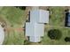Birds-eye view of home with silver roof, red brick walkway surrounded by green lawn and garden at 4895 Cr 134B, Wildwood, FL 34785