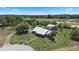 Spacious property with sprawling lawns, mature trees, a detached garage, and lush landscaping viewed from above at 4895 Cr 134B, Wildwood, FL 34785