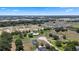 Vast aerial view of a community with homes nestled amongst trees and open plots, set against a blue sky at 4895 Cr 134B, Wildwood, FL 34785