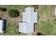 Aerial view of a charming home with a silver roof, complemented by lush greenery and a brick pathway at 4895 Cr 134B, Wildwood, FL 34785