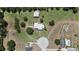 An aerial shot of a property, showing its landscaped grounds, detached garage, circular driveway, and neighboring pool at 4895 Cr 134B, Wildwood, FL 34785