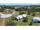 Aerial view of a brick house with a metal roof, a long driveway, and a spacious lot at 4895 Cr 134B, Wildwood, FL 34785