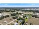 Wide aerial showcases residences with community spaces and open land in a green landscape against a blue sky at 4895 Cr 134B, Wildwood, FL 34785