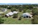 Spacious property featuring a white home with a metal roof and a detached garage, all nestled in a lush green landscape at 4895 Cr 134B, Wildwood, FL 34785