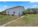 Exterior view of barn featuring white facade, landscaping, and a serene rural setting on a sunny day at 4895 Cr 134B, Wildwood, FL 34785
