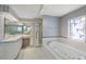 Bathroom featuring a shower, bathtub, vanity, and decorated wallpaper at 4895 Cr 134B, Wildwood, FL 34785