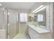 Well-lit bathroom with large vanity, floral wallpaper, and walk-in shower at 4895 Cr 134B, Wildwood, FL 34785
