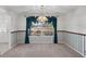 Cozy dining room with carpet, decorative wainscoting, teal curtains, and chandelier, creating a warm and inviting atmosphere at 4895 Cr 134B, Wildwood, FL 34785