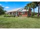 Inviting brick home with a metal roof, large yard, and a covered porch with seating at 4895 Cr 134B, Wildwood, FL 34785