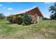 Rear view of a brick home highlighting the well-manicured lawn and two-car garage at 4895 Cr 134B, Wildwood, FL 34785