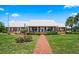 Beautiful brick home with well-manicured landscaping, front porch and walkway at 4895 Cr 134B, Wildwood, FL 34785