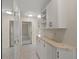 Hallway featuring white cabinets, light tile flooring, and neutral paint at 4895 Cr 134B, Wildwood, FL 34785