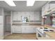 Bright kitchen with white appliances, wood flooring, and lots of natural light at 4895 Cr 134B, Wildwood, FL 34785