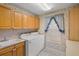 Laundry room with washer, dryer, storage cabinets, and a window at 4895 Cr 134B, Wildwood, FL 34785