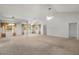 Spacious living room with high ceilings, neutral carpet, large windows, and ceiling fans, providing ample natural light at 4895 Cr 134B, Wildwood, FL 34785