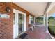 Charming brick porch with a cozy swing, decorative seating, and an inviting front door at 4895 Cr 134B, Wildwood, FL 34785