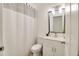Bathroom featuring white cabinets and vanity, shower with curtain, decorative mirror and updated lighting at 5216 Sunrise Blvd, Orlando, FL 32803