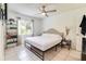 Bright bedroom featuring a ceiling fan, large window, and a bed with black metal frame and tufted headboard at 5216 Sunrise Blvd, Orlando, FL 32803