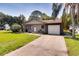 Charming single-story home with a well-manicured lawn, mature trees, and a private driveway at 5216 Sunrise Blvd, Orlando, FL 32803