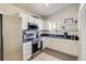 Bright kitchen with white cabinets, stainless steel appliances, and a modern backsplash at 5216 Sunrise Blvd, Orlando, FL 32803