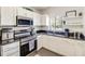 Well-lit kitchen with white cabinetry, stainless steel appliances, and a double basin sink at 5216 Sunrise Blvd, Orlando, FL 32803