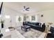Bright living room featuring a large blue couch, white curtains, and neutral-toned tiles at 5216 Sunrise Blvd, Orlando, FL 32803