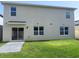 Backyard view featuring a sliding glass door and lush green grass perfect for outdoor activities at 5350 Pine Lilly Dr, St Cloud, FL 34771