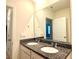Bathroom with double vanity featuring granite countertops, and a large mirror at 5350 Pine Lilly Dr, St Cloud, FL 34771