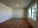 Bedroom with cozy brown carpet and a large window, offering a serene and adaptable space at 5350 Pine Lilly Dr, St Cloud, FL 34771