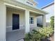 Covered front porch with a dark blue front door and well manicured landscaping at 5350 Pine Lilly Dr, St Cloud, FL 34771