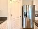 Modern kitchen with stainless steel refrigerator and granite countertops, providing style and functionality at 5350 Pine Lilly Dr, St Cloud, FL 34771