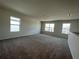 Spacious carpeted loft area featuring large windows, providing natural light at 5350 Pine Lilly Dr, St Cloud, FL 34771