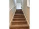 Carpeted staircase leading to the upper level of the home, featuring white railing at 5350 Pine Lilly Dr, St Cloud, FL 34771