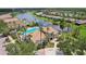 Aerial view of community pool and clubhouse near lake, showcasing a resort-style living environment at 636 Grand Canal Dr, Kissimmee, FL 34759