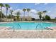 Inviting community pool with a zero entry, complete with palm trees, lounge chairs, and a relaxing atmosphere at 636 Grand Canal Dr, Kissimmee, FL 34759
