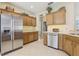 Traditional kitchen featuring stainless steel appliances, tiled floors, and wood cabinetry at 636 Grand Canal Dr, Kissimmee, FL 34759