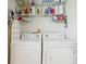 Functional laundry room with a washer and dryer, shelves, and storage solutions at 636 Grand Canal Dr, Kissimmee, FL 34759