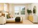 Bright bedroom with large window, neutral walls, and rattan accents for a relaxing space at 773 Tundra Loop, Groveland, FL 34736