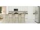 Modern kitchen with white cabinets, stainless steel appliances, and a center island with bar stool seating at 773 Tundra Loop, Groveland, FL 34736