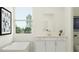 Bright bathroom boasts a window with beautiful views, a tub for soaking, and stylish fixtures and storage at 809 Tundra Loop, Groveland, FL 34736