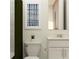 Bathroom featuring a white vanity, toilet, and tub with a dark green shower curtain and artwork at 809 Tundra Loop, Groveland, FL 34736